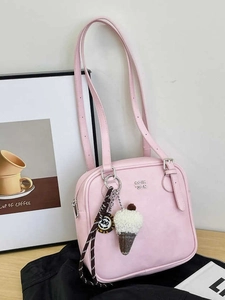 Pink faux leather underarm bag with silver logo and ice cream charm on a wooden stand