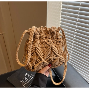Close-up of beige woven bucket bag with drawstring closure and decorative wooden beads