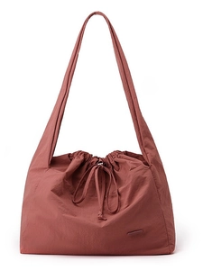 Waterproof nylon tote bag in brick red featuring a minimalist drawstring design