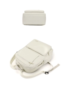Vue détaillée du sac à dos en nylon blanc crème montrant le fond plat et poches latérales