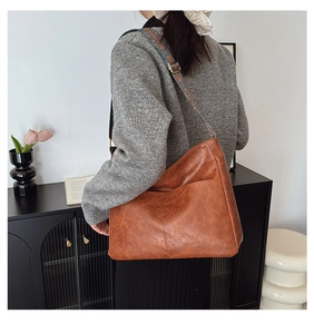Detail of vintage brown tote bag featuring colorful ethnic style wide embroidery strap