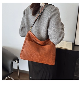 Detail of vintage brown tote bag with colorful ethnic style woven wide shoulder strap