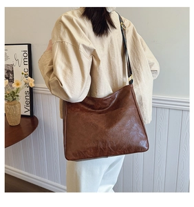 Detail of vintage brown PU leather tote bag with ethnic print wide shoulder strap