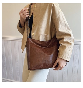 Brown vintage shoulder bag with ethnic style jacquard strap shown on a model
