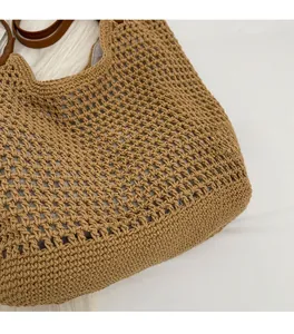 Detail of hand-woven cotton mesh tote bag with premium brown leather handles