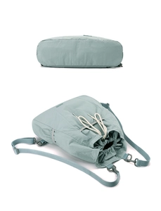 Vista de detalle de la mochila de nailon verde menta con cordón blanco y bolsillo lateral