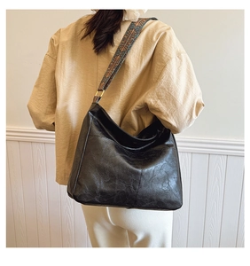 Detail of black faux leather tote with colorful ethnic pattern wide shoulder strap