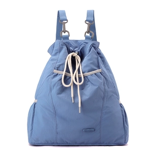 Detalle de la mochila de nailon azul ligero con cierre de cordón y bolsillos exteriores