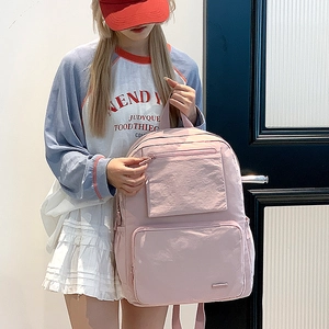 Détail du sac à dos en nylon rose avec plusieurs poches pour les étudiantes