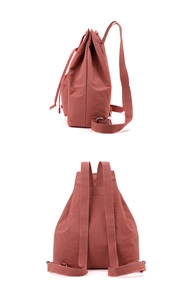 Detail of drawstring backpack with white contrast stitching and coral pink nylon fabric