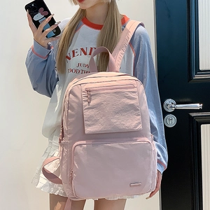 Détail d'un sac à dos en nylon rose avec poches zippées doubles et poche latérale utile