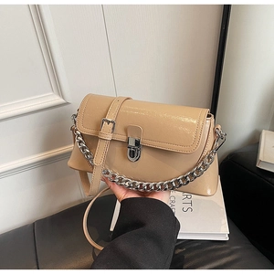 Detail of apricot glossy PU leather handbag with silver metal lock and chain strap