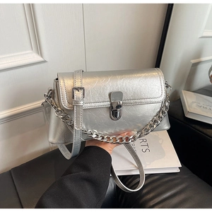 Detail of silver metallic leather texture and metal buckle on the women square bag