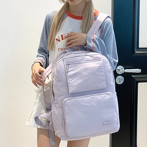 Détail macro du sac à dos en nylon lavande avec doubles poches avant zippées et latérales