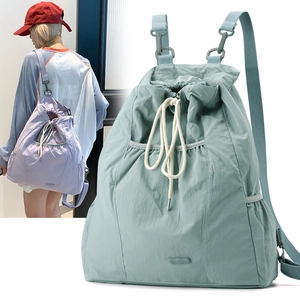 Detalle de mochila de nailon impermeable con cierre de cordón y bolsillos laterales