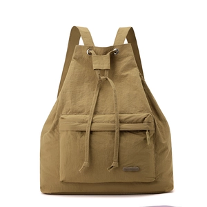 Close-up of khaki drawstring backpack featuring high-density nylon fabric and zipper pocket