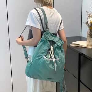 Detalle de la mochila de nailon verde menta con cordón ajustable y correas para hombros