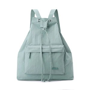 Detail view of light green nylon backpack with drawstring closure and metal eyelets