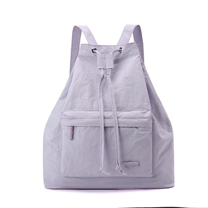 Detail of light purple drawstring backpack featuring front zipper pocket and nylon texture