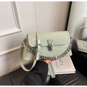 Detail of mint green glossy shoulder bag with silver chain and metal clasp closure