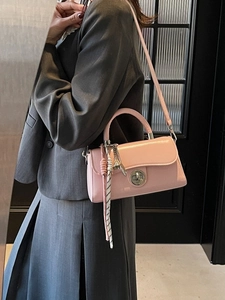 Roze lederen crossbody tas met zilveren draaisluiting en geweven detail op model