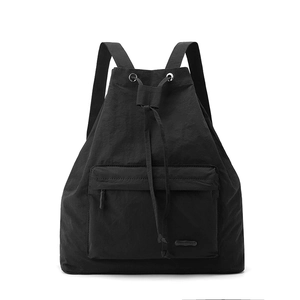 Detail of black nylon drawstring backpack featuring textured fabric and metal eyelets