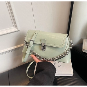Detailed shot of mint green patent leather bag with silver chain and metal twist lock