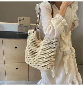 Beigefarbene Häkeltasche mit braunen Lederriemen, von Model im Boho-Stil getragen