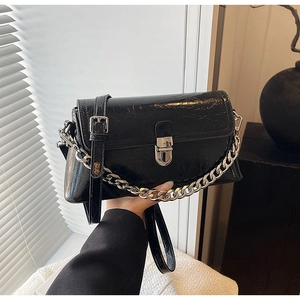 Detail of black glossy crackle texture handbag with silver chain and metal buckle
