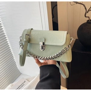 Detail of mint green crossbody bag featuring wrinkled texture and silver chain