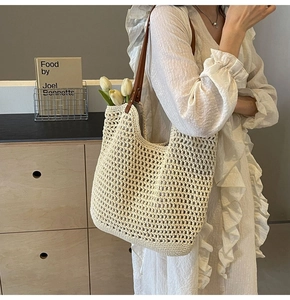 Detail der gewebten Stroh-Tote-Bag mit braunen Lederriemen und Vintage-Metallnieten