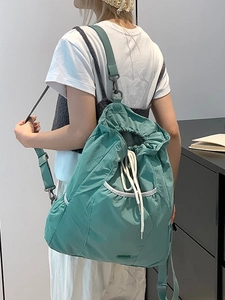 Mochila de nailon verde menta con cordón, bolsillo frontal de luna y ribete blanco