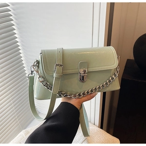 Detail of mint green patent leather handbag with silver chunky chain and metal turn-lock