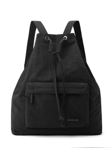 Minimalist black nylon drawstring backpack with front zipper pocket and metal eyelets