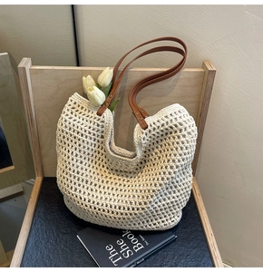 Detail des handgewebten Netzmusters der beigen Strohtasche mit braunen Kunstlederriemen