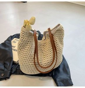 Detail der handgewebten Strohtasche mit braunen Ledergriffen und Deko-Tulpen
