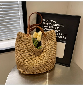Nahaufnahme der handgewebten Strohtasche mit braunen Ledergriffen und hohlem Häkeldetail