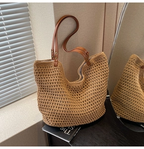 Detailaufnahme der handgewebten Stroh-Tote-Bag mit braunen Kunstledergriffen und Nieten