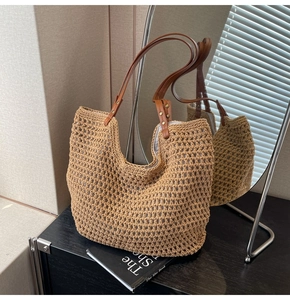 Detail der gewebten Strohtasche mit hohlem Maschenmuster und braunen Lederriemen