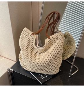 Detail der beigen Häkeltasche mit gewebter Netzstruktur und braunen Kunstlederriemen