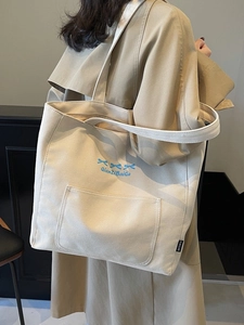 Large cream canvas tote bag with blue bow print and comfortable shoulder strap