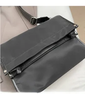 Detail of durable black nylon fabric texture and silver metal buckle on the shoulder bag