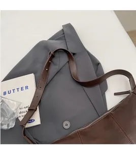 Detail of dark brown leather crescent bag with smooth adjustable long shoulder strap