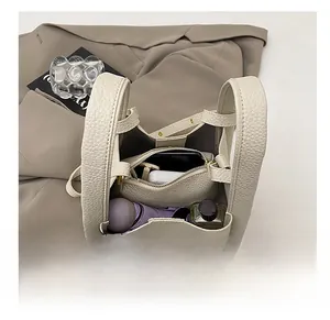 Internal storage view of beige lychee leather bucket bag showing multiple compartments