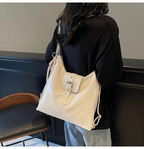 Détail d'un sac fourre-tout en similicuir crème avec boucles métalliques et sangle