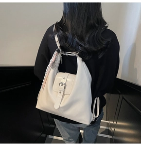 Détail d'un sac à dos en cuir PU beige avec boucles et décoration foulard en soie élégante