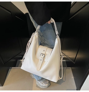 Détail d'un sac hobo blanc en cuir verni avec boucle et foulard en soie décoratif élégant