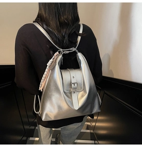 Sac à dos argenté métallisé avec breloques tressées porté par un mannequin en vue