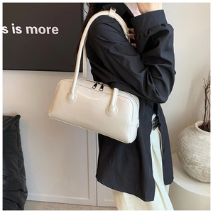 Detailed side view of off-white leather Boston bag with embossed SHIYUBAG logo