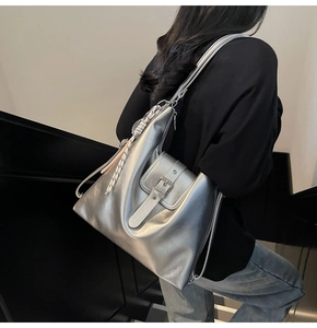 Détail du sac à dos argenté métallisé avec boucle et accessoire de foulard géométrique